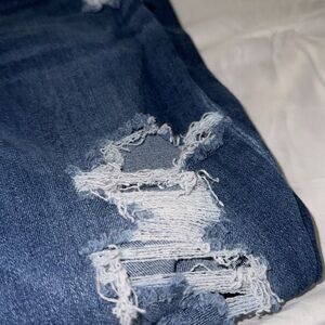Light dark blue jeans with many rips